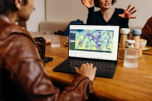 Project collaborators discussing a vegetation-change map on a laptop.